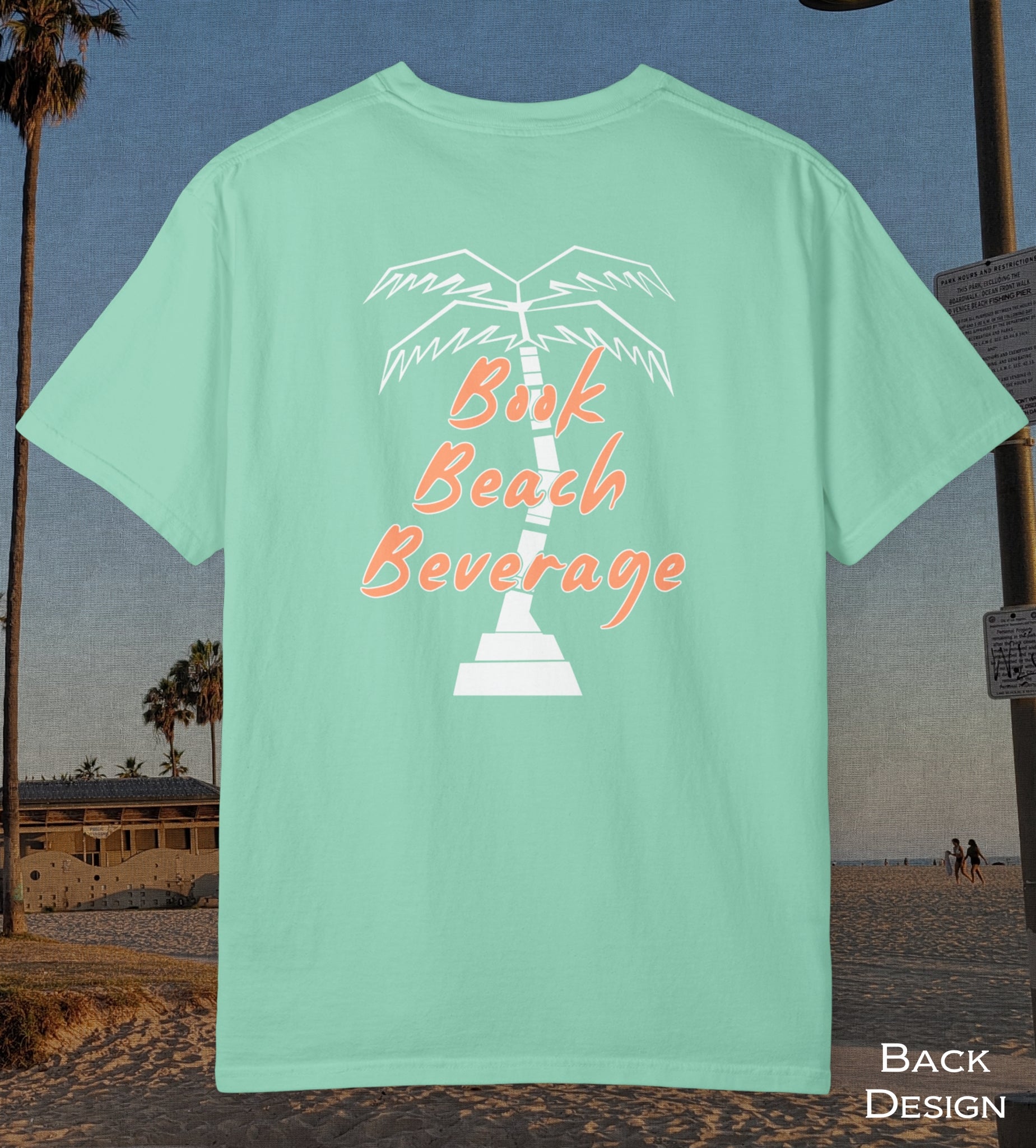 Comfort Colors cotton t-shirt Island reef green in color featuring durable DTF back design of a white palm tree and the words Book Beach Beverage in orange.