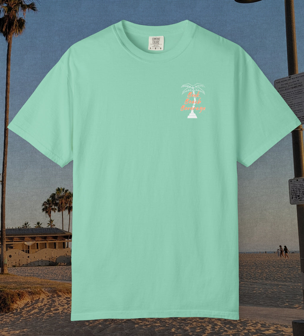 Comfort Colors cotton t-shirt Island reef green in color featuring durable DTF front left chest design design of a white palm tree and the words Book Beach Beverage in orange.