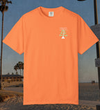 Comfort Colors cotton t-shirt Melon orange in color featuring durable DTF front left chest design design of a white palm tree and the words Book Beach Beverage in light green.