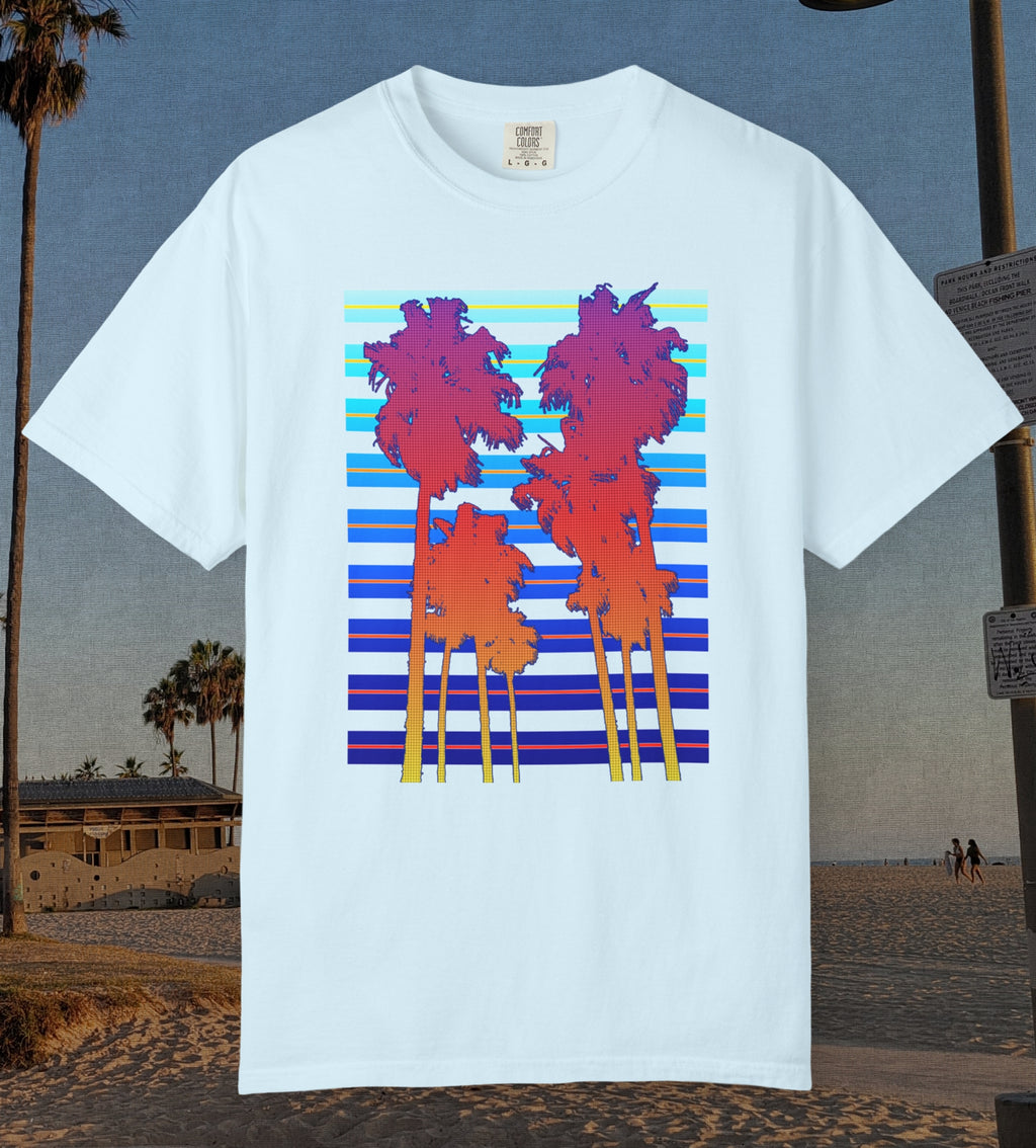 Comfort Colors cotton t-shirt Chambray/Light blue in color featuring a DTF graphic of palm tree silhouettes in warm colors with a cool color background pattern.