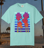 Comfort Colors cotton t-shirt Chalky Mint Green in color featuring a DTF graphic of palm tree silhouettes in warm colors with a cool color background pattern.