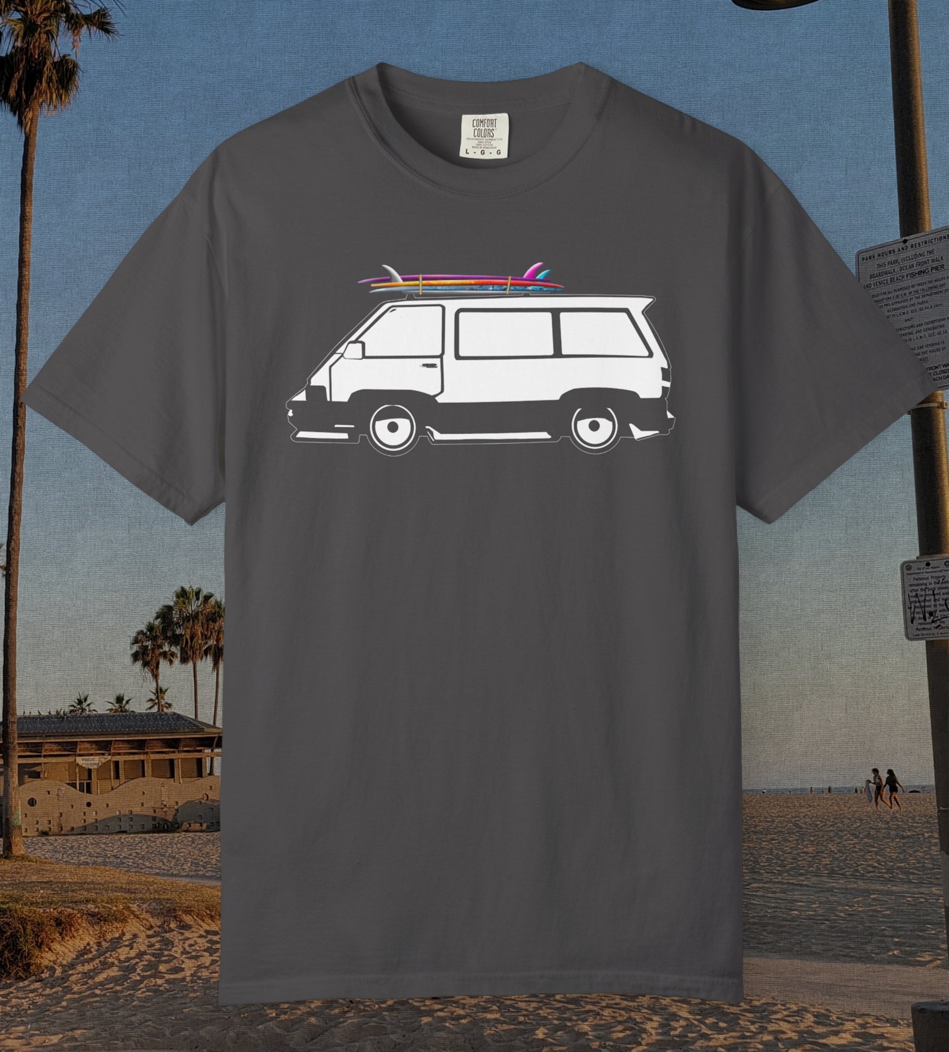 A dark gray crewneck t-shirt featuring a white graphic of a classic van with surfboards on its roof, set against a beach background.