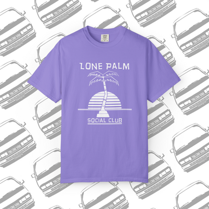 Violet purple Comfort Colors graphic t-shirt with DTF  'Lone Palm Social Club' palm tree graphic on a background with van silhouettes.