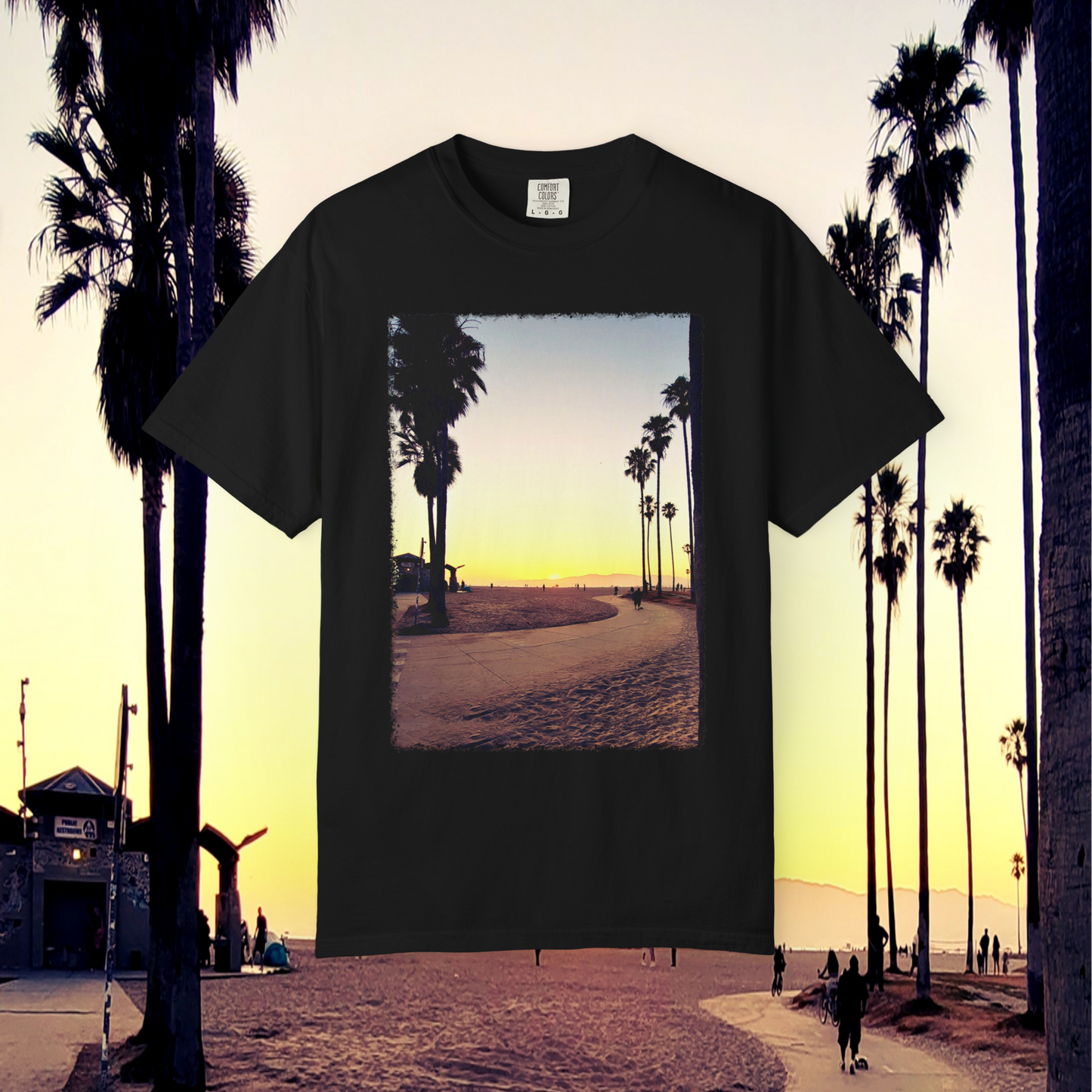 Black t-shirt with a beach and palm tree design on a background of palm trees and a sunset at Venice Beach