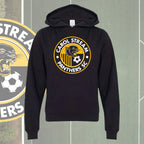 A youth black pullover hoodie featuring a circular 'Carol Stream Panthers SC' graphic on the chest, displayed against a green soccer field background with a team logo partially visible on the left.